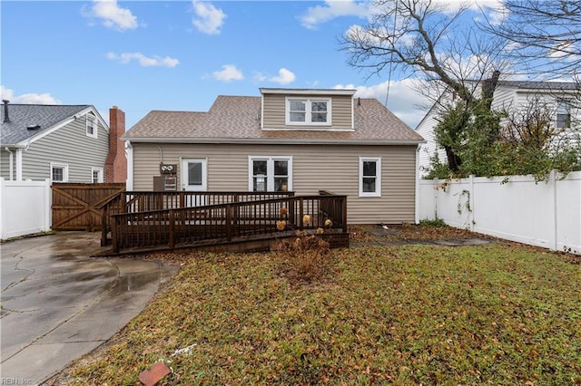 rear view of house with a yard and a deck