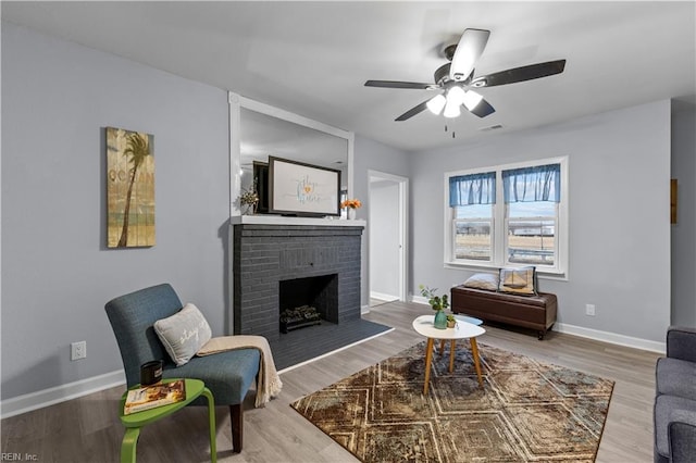 living room with a fireplace, hardwood / wood-style flooring, and ceiling fan