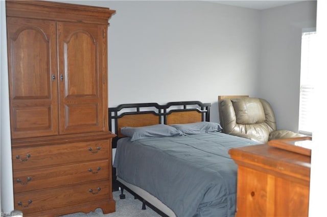 bedroom featuring light colored carpet and multiple windows