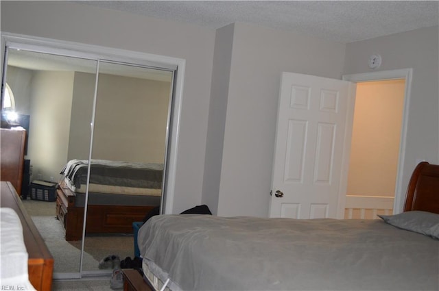 bedroom featuring carpet floors, a textured ceiling, and a closet