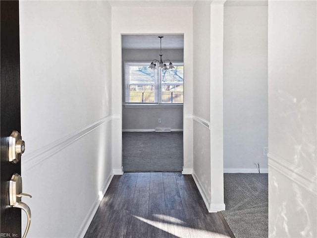 hall with a chandelier and dark hardwood / wood-style floors