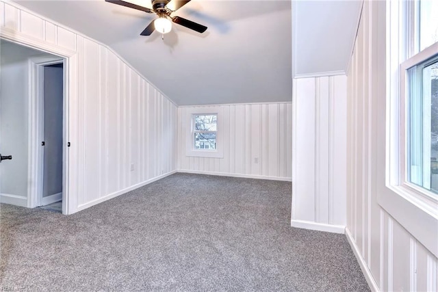 bonus room featuring ceiling fan, a healthy amount of sunlight, vaulted ceiling, and light carpet