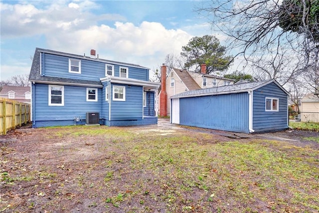 back of property featuring a lawn and an outbuilding