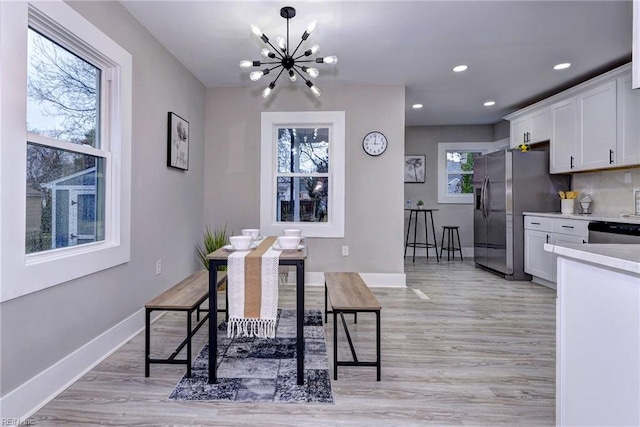 dining room with a notable chandelier and light wood-type flooring