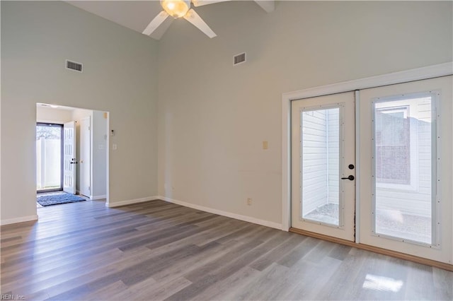 unfurnished room with ceiling fan, wood-type flooring, and high vaulted ceiling