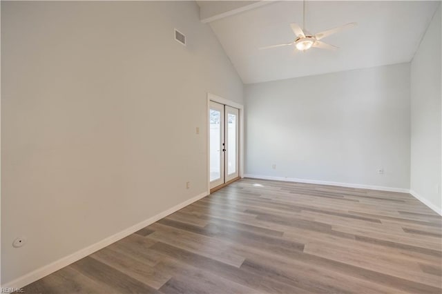 empty room featuring ceiling fan, light wood-type flooring, high vaulted ceiling, and french doors