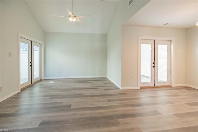 empty room with light hardwood / wood-style floors, a wealth of natural light, and french doors