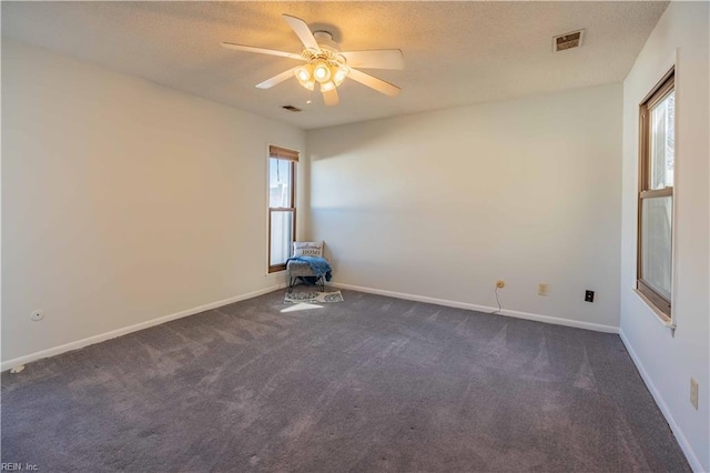 carpeted spare room with ceiling fan and a wealth of natural light