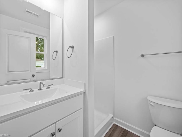 bathroom with vanity, hardwood / wood-style flooring, toilet, and walk in shower