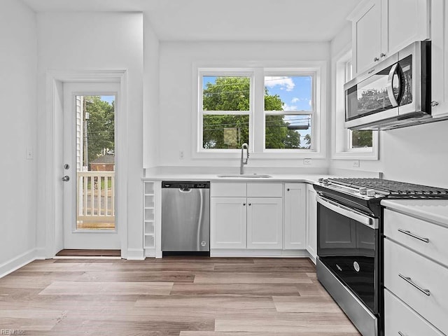 kitchen featuring white cabinets, plenty of natural light, sink, and appliances with stainless steel finishes