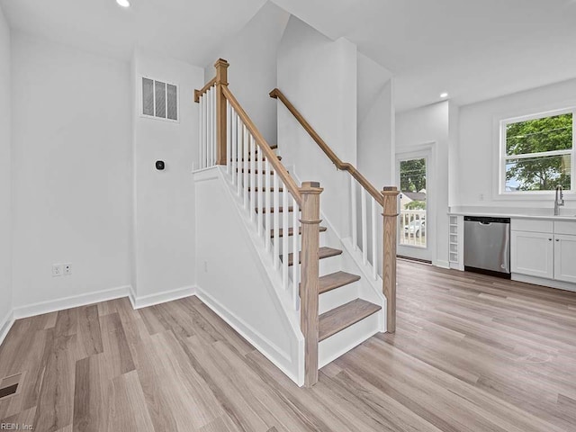 stairs with wood-type flooring and sink