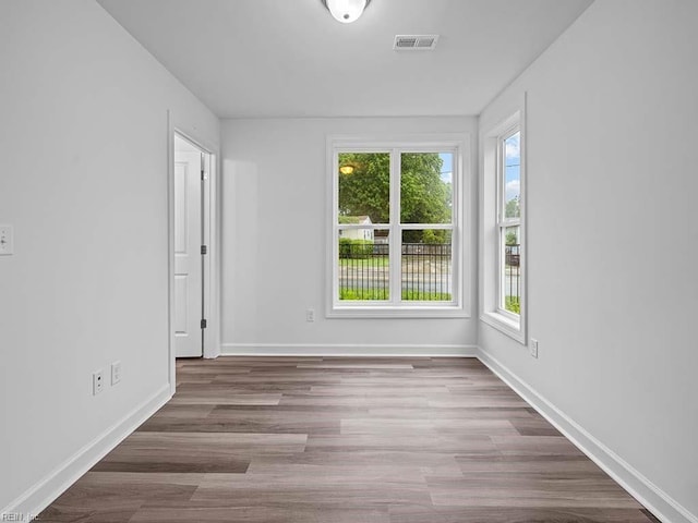 spare room with plenty of natural light and hardwood / wood-style floors