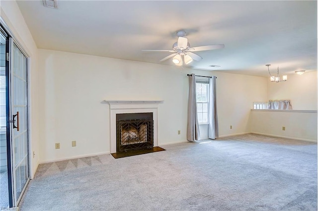 unfurnished living room with carpet and ceiling fan with notable chandelier