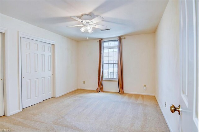 unfurnished bedroom with light carpet and ceiling fan