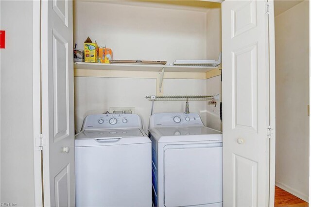 laundry area with separate washer and dryer and hardwood / wood-style flooring