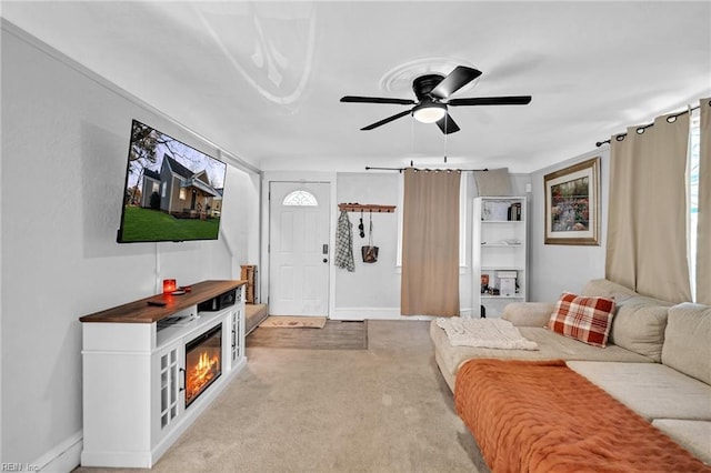 carpeted living room with a fireplace and ceiling fan