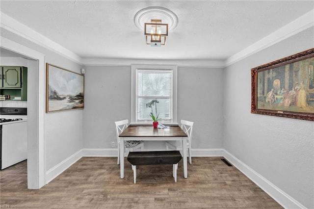 dining area featuring crown molding and light wood-type flooring