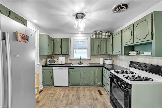 kitchen with sink, light hardwood / wood-style floors, white appliances, and green cabinetry