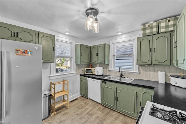 kitchen with white appliances, light hardwood / wood-style floors, green cabinets, and sink