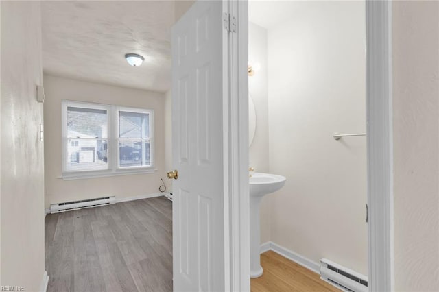 bathroom with hardwood / wood-style flooring and a baseboard radiator