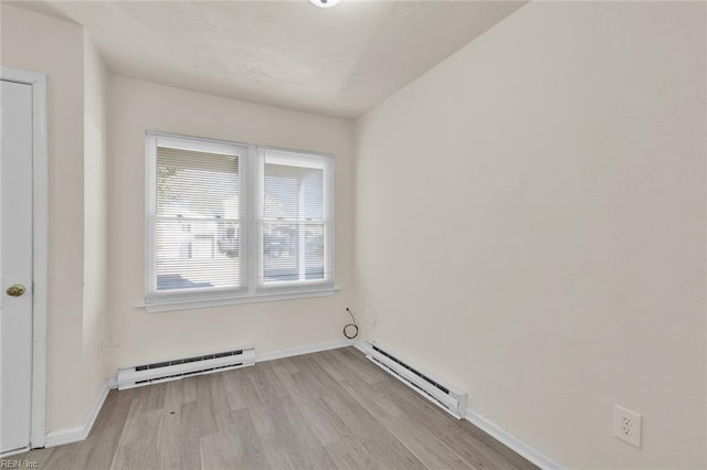 empty room with light hardwood / wood-style floors and baseboard heating