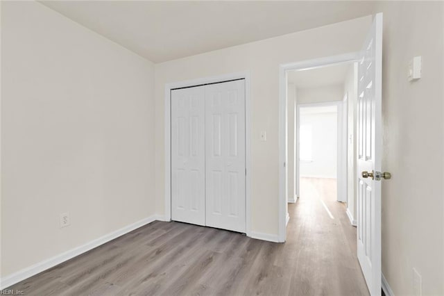 unfurnished bedroom with light hardwood / wood-style floors and a closet