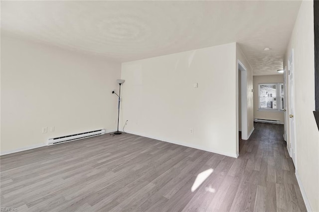 spare room featuring light hardwood / wood-style flooring and a baseboard heating unit