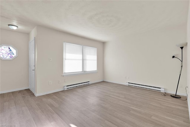 foyer entrance featuring a baseboard radiator and light hardwood / wood-style flooring