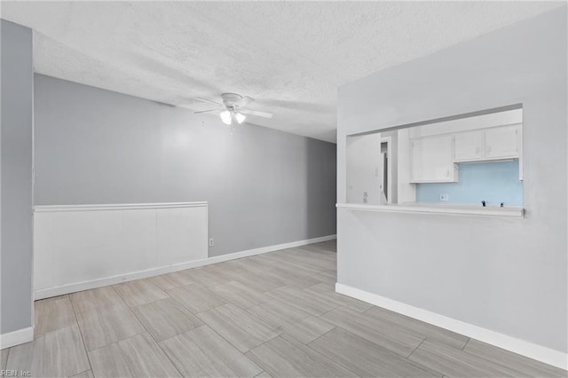 empty room with a textured ceiling and ceiling fan