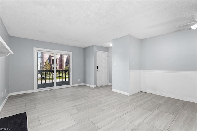 spare room with ceiling fan and a textured ceiling