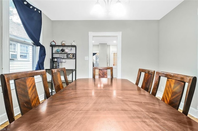 dining area featuring hardwood / wood-style flooring, a wealth of natural light, and a notable chandelier