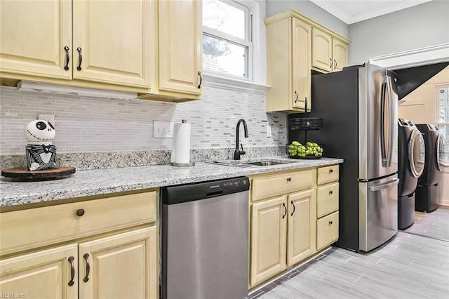 kitchen with washer and clothes dryer, light brown cabinets, sink, light stone countertops, and appliances with stainless steel finishes