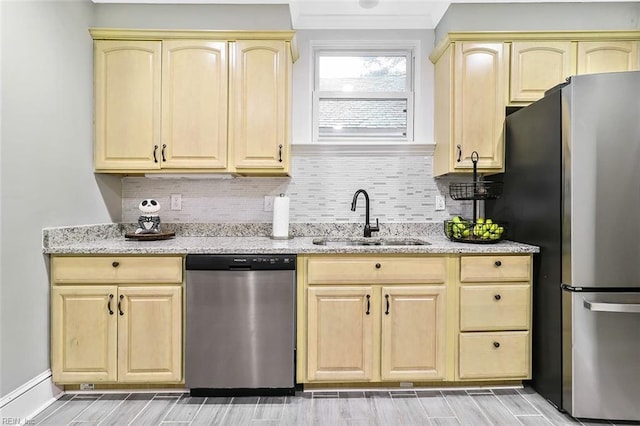 kitchen with light stone countertops, appliances with stainless steel finishes, backsplash, and sink