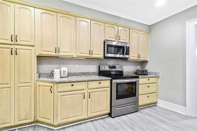 kitchen featuring light stone countertops, tasteful backsplash, stainless steel appliances, light brown cabinets, and light hardwood / wood-style flooring