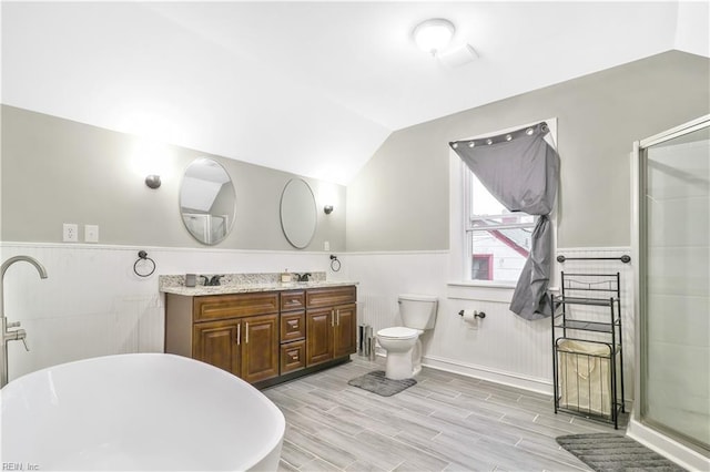 full bathroom featuring hardwood / wood-style floors, vaulted ceiling, toilet, vanity, and shower with separate bathtub