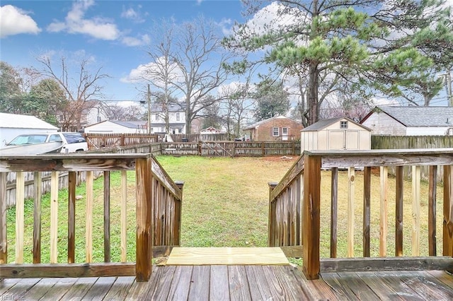 wooden terrace with a storage shed and a yard