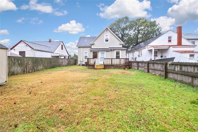 back of property with a lawn and a wooden deck