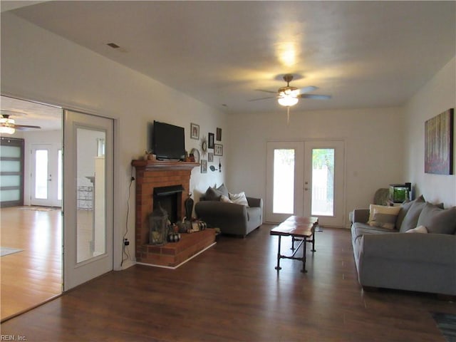 living room with french doors, ceiling fan, and dark wood-type flooring