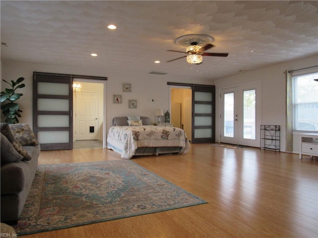 bedroom featuring access to exterior, light hardwood / wood-style floors, and ceiling fan