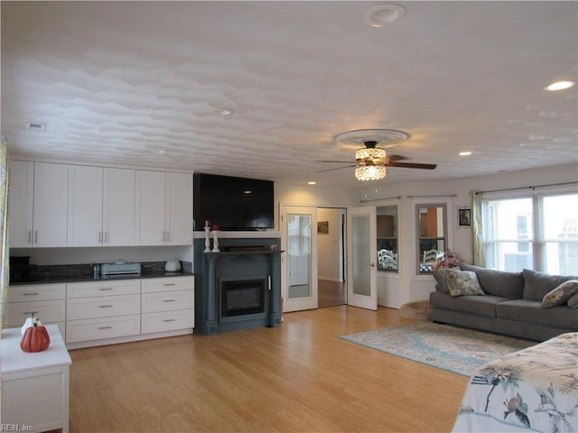 living room with ceiling fan and light hardwood / wood-style floors