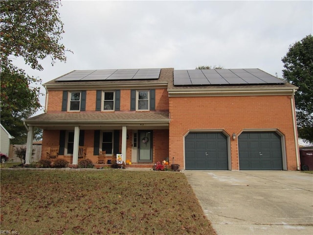 view of front of property with solar panels, a garage, covered porch, and a front lawn