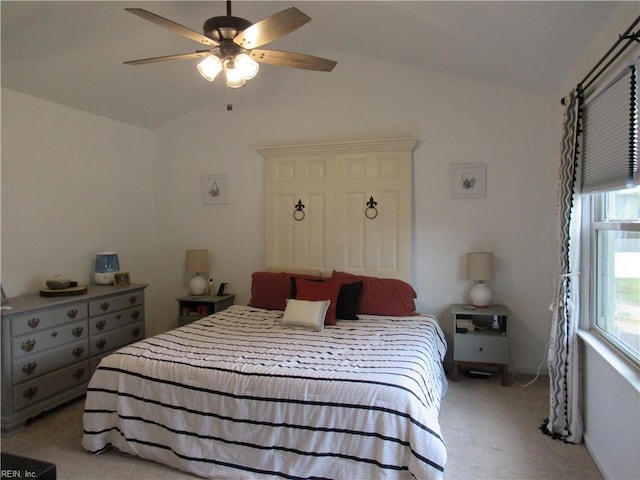 bedroom with ceiling fan, light colored carpet, and vaulted ceiling