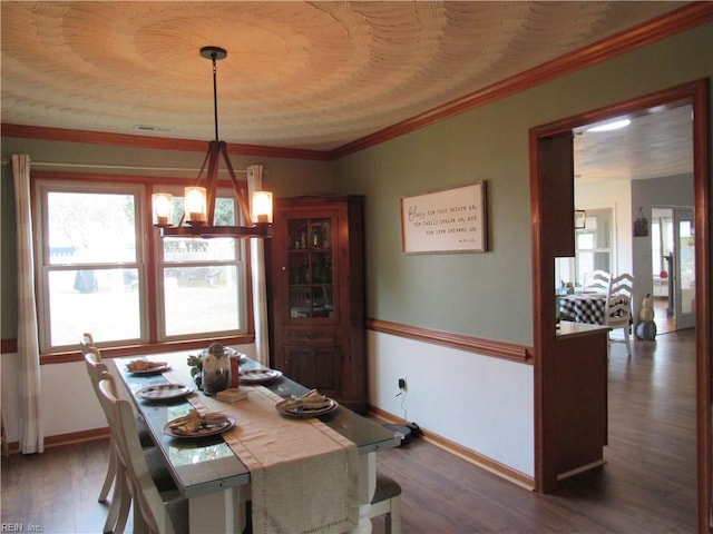 dining space featuring a chandelier, dark wood-type flooring, and crown molding