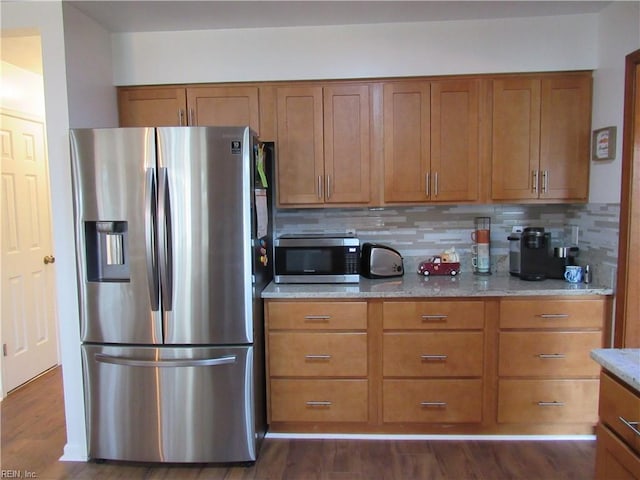 kitchen featuring backsplash, light stone counters, stainless steel appliances, and dark wood-type flooring