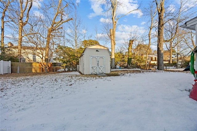 yard covered in snow with a shed