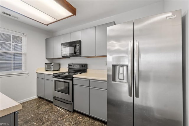 kitchen featuring gray cabinetry and appliances with stainless steel finishes