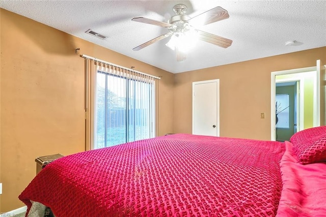 bedroom with ceiling fan and a textured ceiling