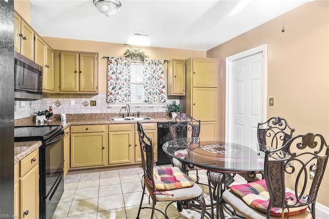 kitchen featuring backsplash, light stone counters, sink, black appliances, and light tile patterned flooring