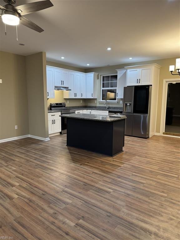 kitchen with white cabinets, a center island, stainless steel appliances, and hardwood / wood-style flooring