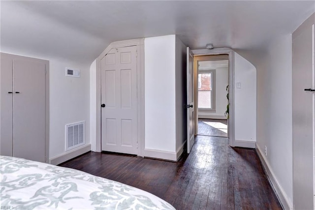 unfurnished bedroom featuring dark wood-type flooring and lofted ceiling